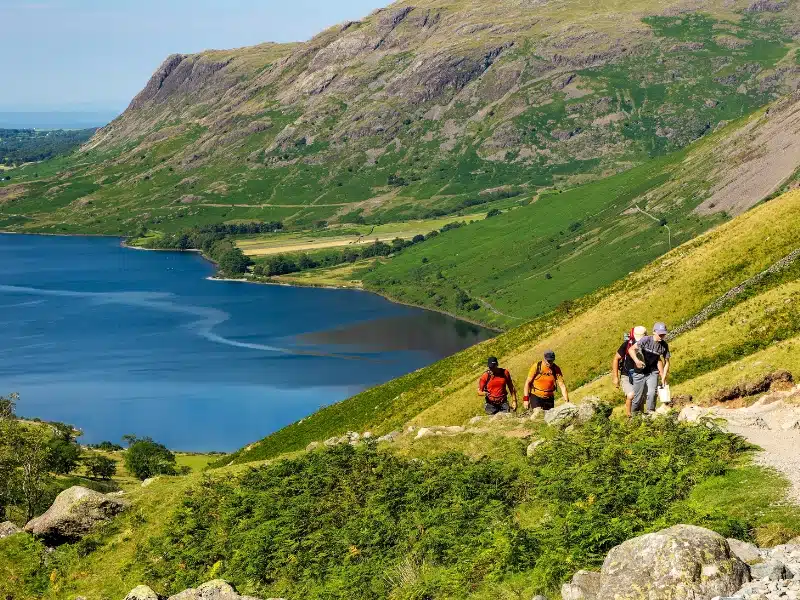 Hikers ascending England's talltest mountain, Scafell Pike via Wasdale Head with Wastwater in the background
