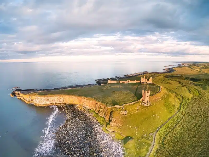 View from above of the ruins of Dunstanburgh Castle, Embleton Bay in Northumberland.