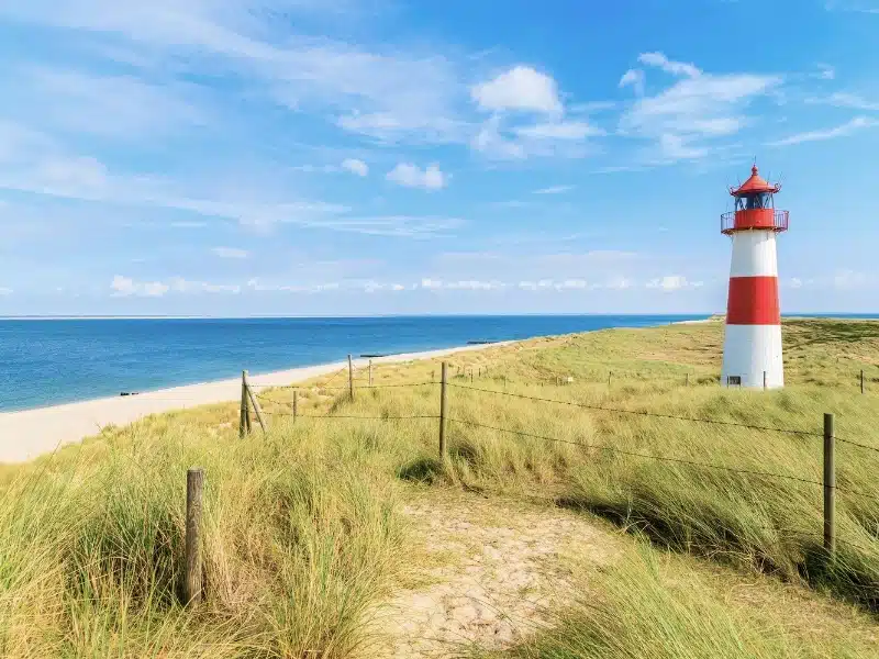 Ellenbogen Lighthouse with grassy sand dunes and a beach view on northern coast of Sylt Island in Germany