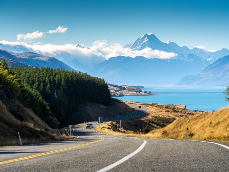 Scenic road trip of Mt Cook or Aoraki over winding road and Lake Pukaki on sunny day at Peters lookout, New Zealand