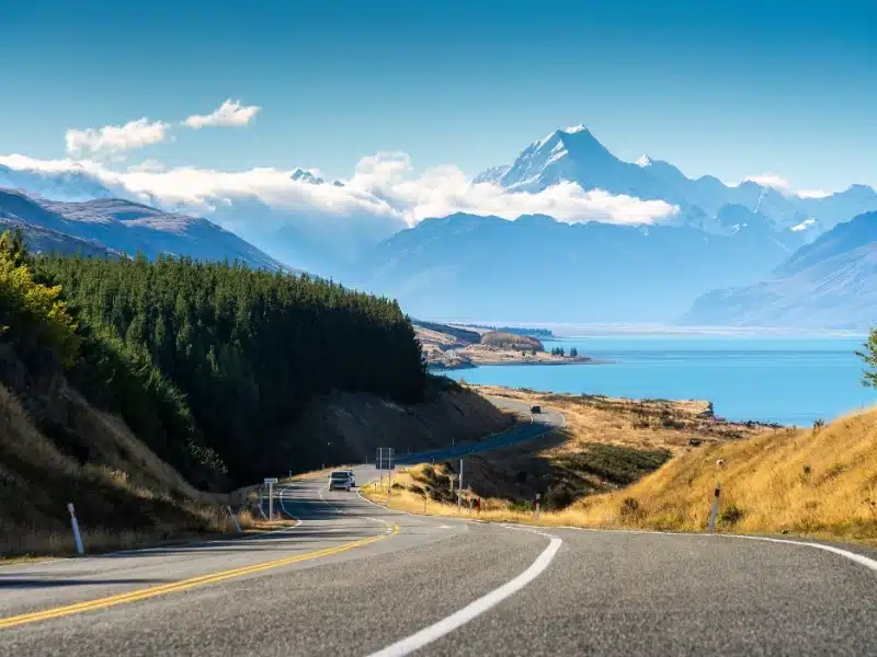 Scenic road trip of Mt Cook or Aoraki over winding road and Lake Pukaki on sunny day at Peters lookout, New Zealand