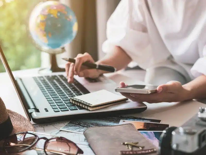 Traveler planning vacation trip and searching information or booking hotel on laptop