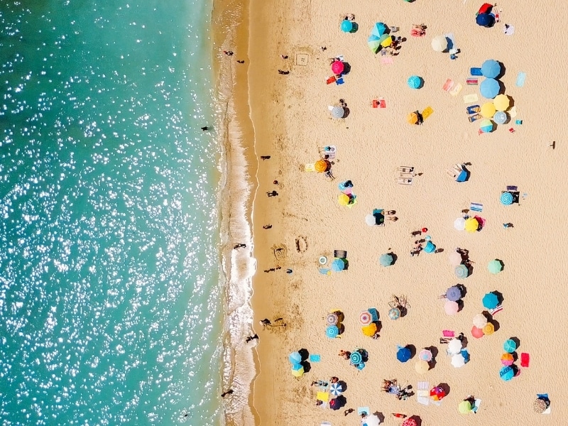 Aerial view of people under parasonls on a beach in Portugal