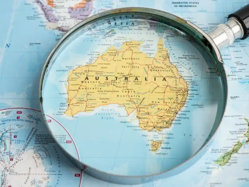Magnifying glass close up with colorful Australian map, travel, geography, tourism and exploration.