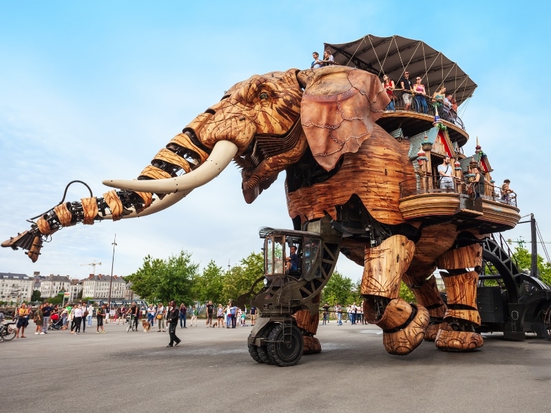 Large mechanical elephant carrying people through Nantes