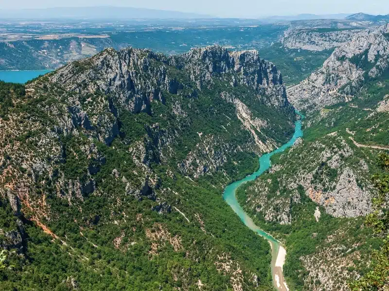 Ariel image of a turquoise river in a deep and wooded gorge surrounded by rocky outcrops