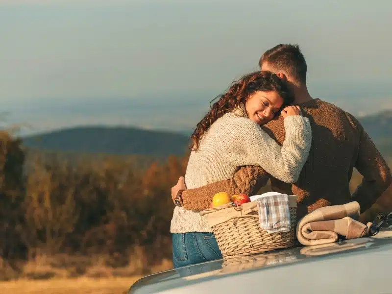 couple by a car with a picnic