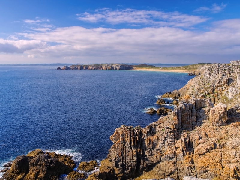 View from rocky cliffs over the ocean to a peninsula and beaches