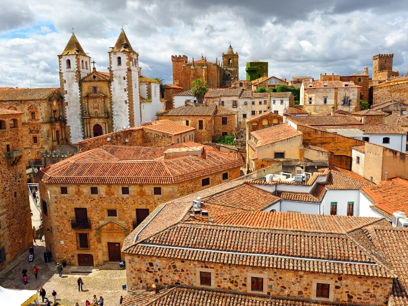 Terracotta tiled rooftops and a white painted church in a medieval city