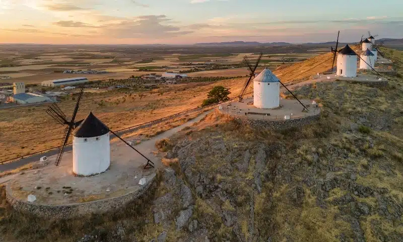 Old historic windmills of Don Quixote character on the hills in evening light. Molinos de Viento de Consuegra