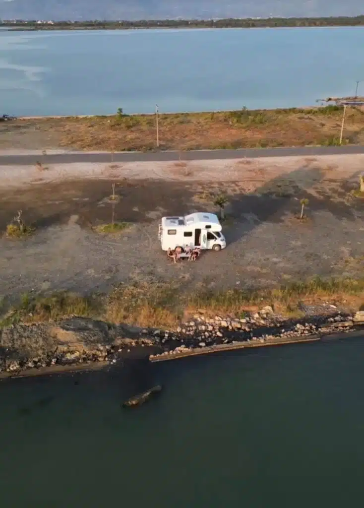 Drone shot of a motorhome parked between a river and large body of water