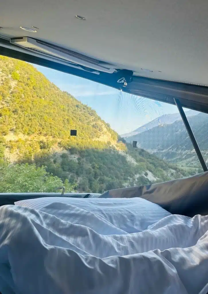 View from a campervan poptop of mountains covered in lush greenery