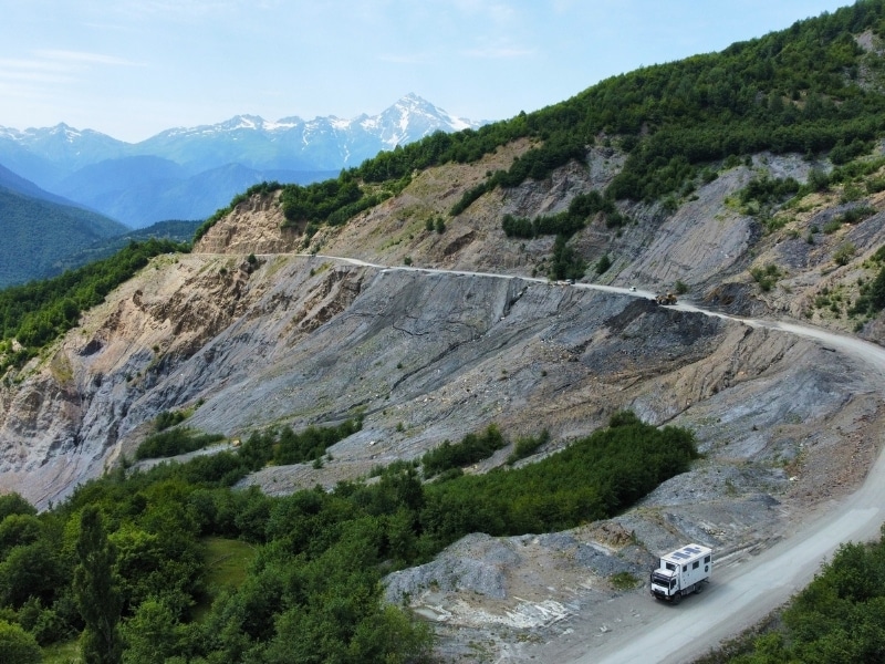 truck on a gravel mountain round with mountains in the background