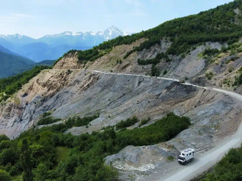 truck on a gravel mountain round with mountains in the background