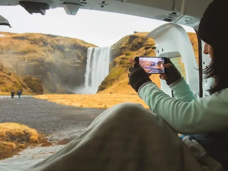 Traveler woman shoot video photo of beautiful waterfall use smartphone.