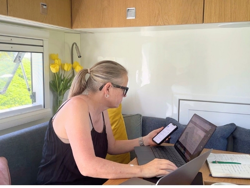 Woman at a table in a motorhome working on a laptop