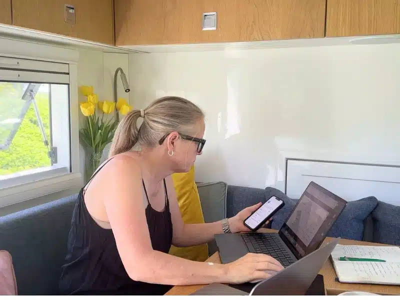 Woman at a table in a motorhome working on a laptop
