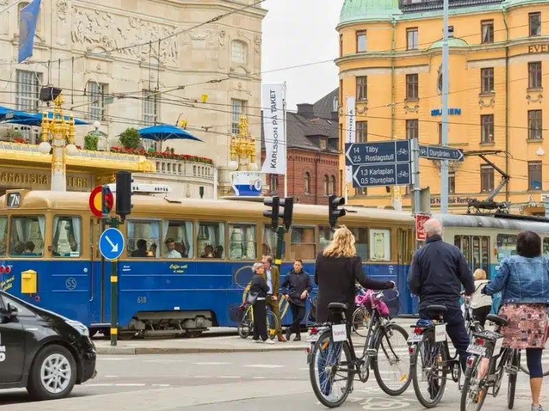 Traffic in city center. Tram, people, taxi and bike riders.