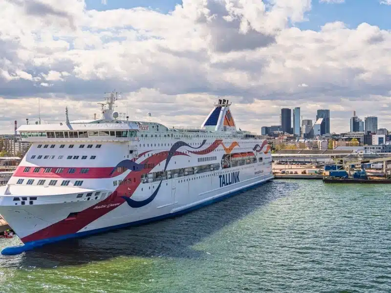 A modern ferry boat docked at the port in Tallinn, Estonia, showcasing the city skyline in the background.