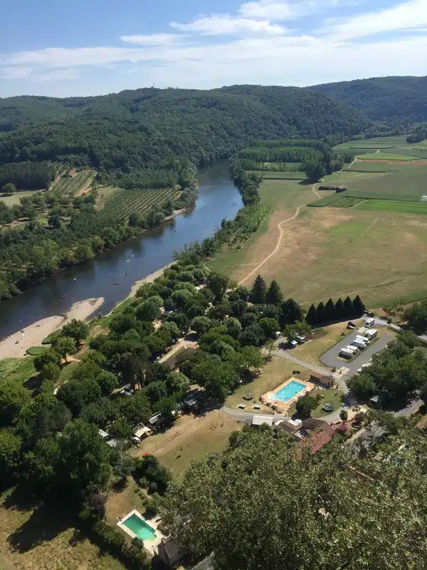 View across green fields, a wide river and a motorhome aire