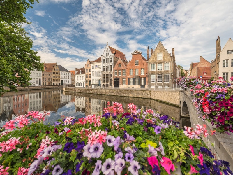 Bruges Belgium, city skyline at Spiegelrei Canal with summer flowers