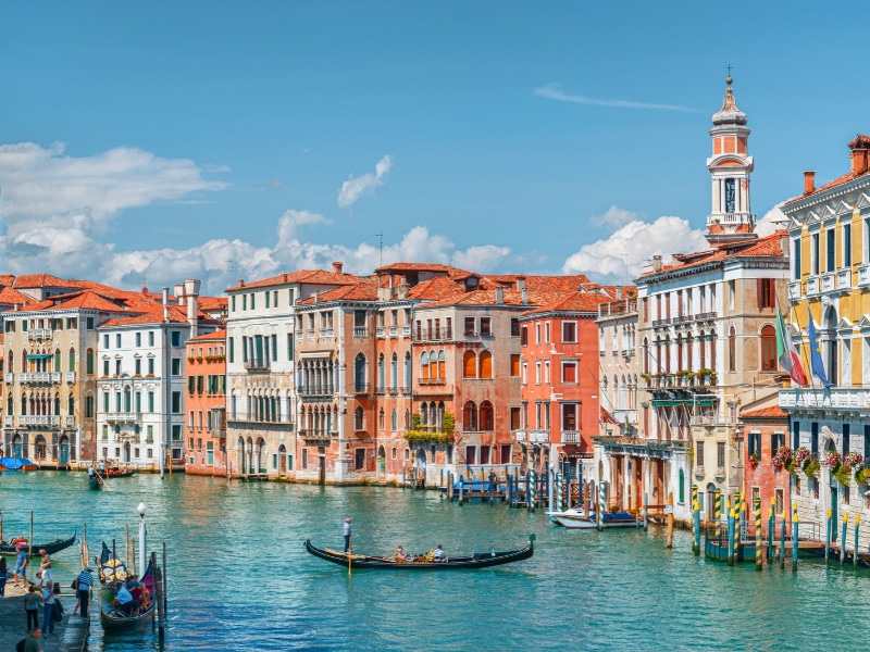 Beautiful view of the Grand Canal with boats and colorful facades of old medieval houses from the Rialto Bridge in Venice, Italy. Venice is a popular tourist destination of Europe.