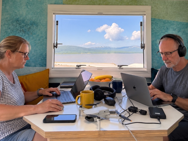couple at a camper table working on laptops
