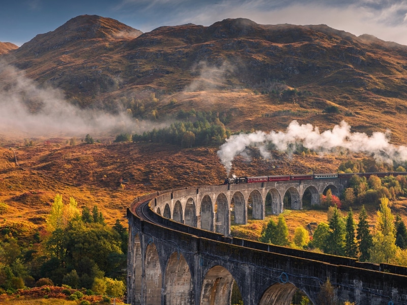 The morning train steams across the Glenfinnan Viaduct, its plume rising against the Highland mist.