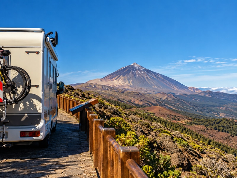 Motorhome parked at a scenic viewpoint overlooking Mount Teide and the volcanic landscape of Tenerife in the Canary Islands.