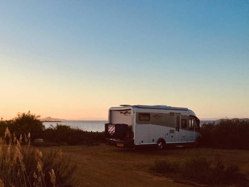 motorhome camped on a sany sport at dusk
